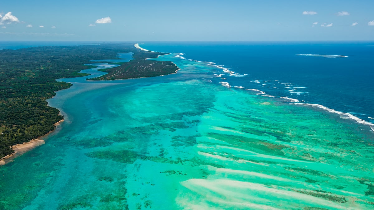 Aerial of turquoise reefs and lagoon coastline, Madagascar
